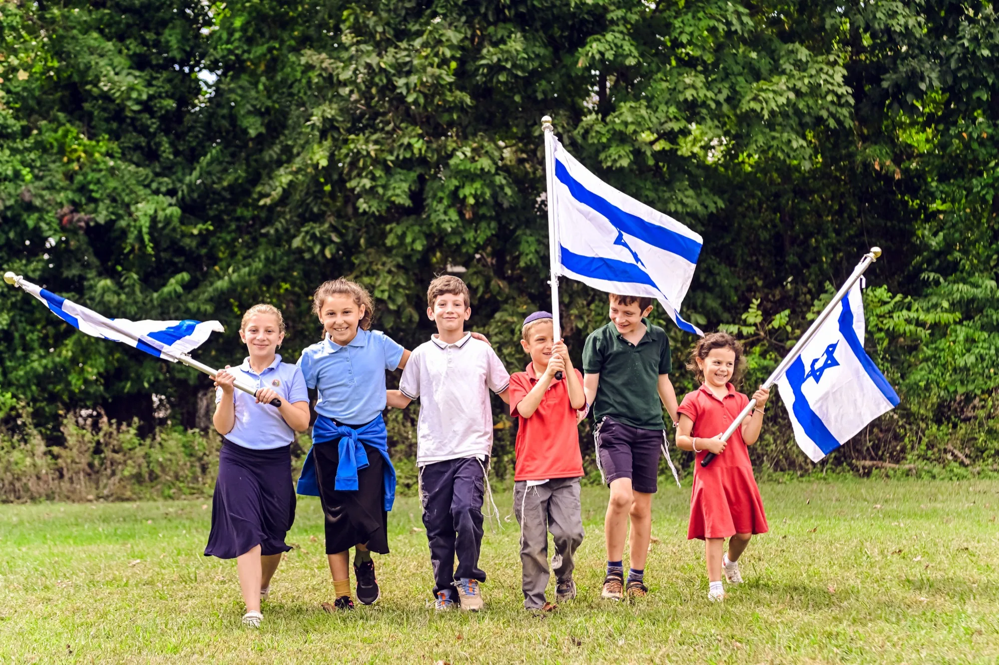 OCA students walking together while carrying Israeli flags