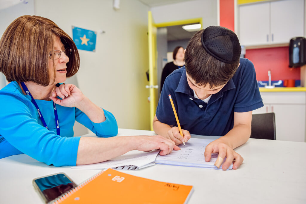 An OCA academic support teacher working individually with a student